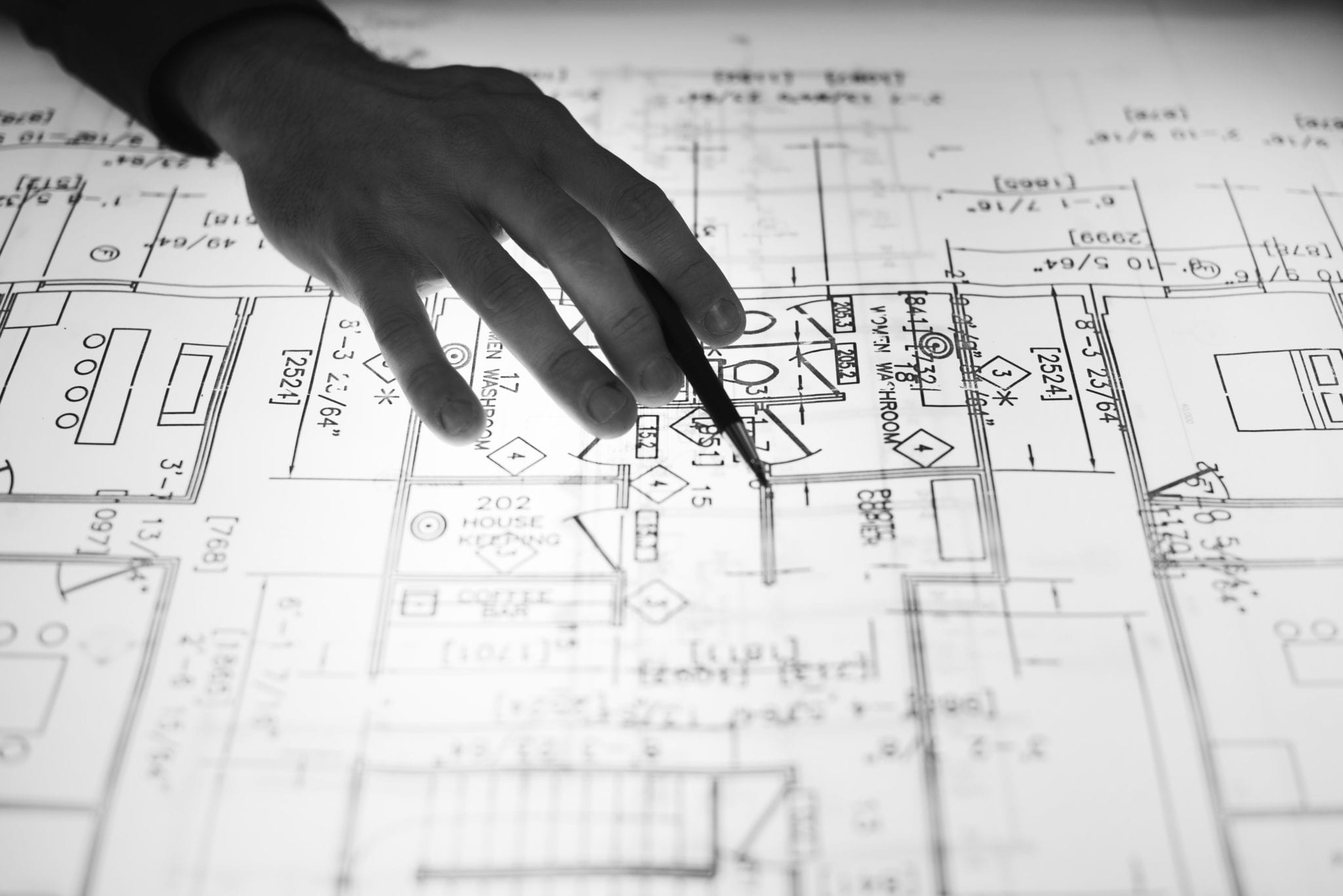 hand pointing to an area on a blueprint